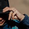 Man grabbing the brim of his hat with his hand and a silicone ring on his finger